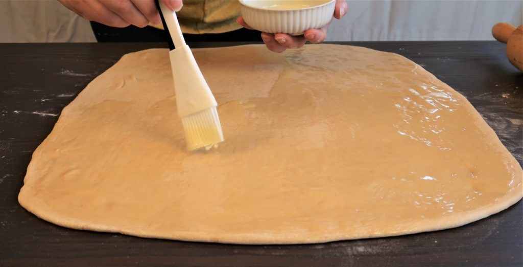 brushing butter on dough